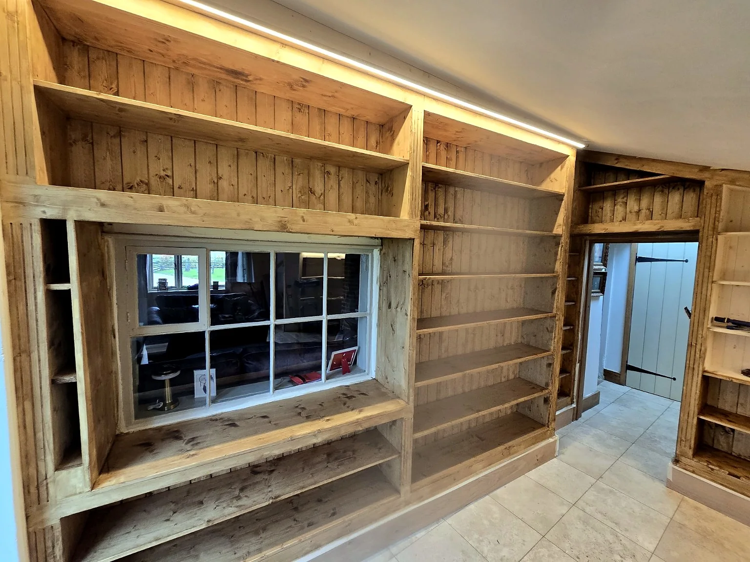 Bespoke built-in shelving around a window by SM Installations