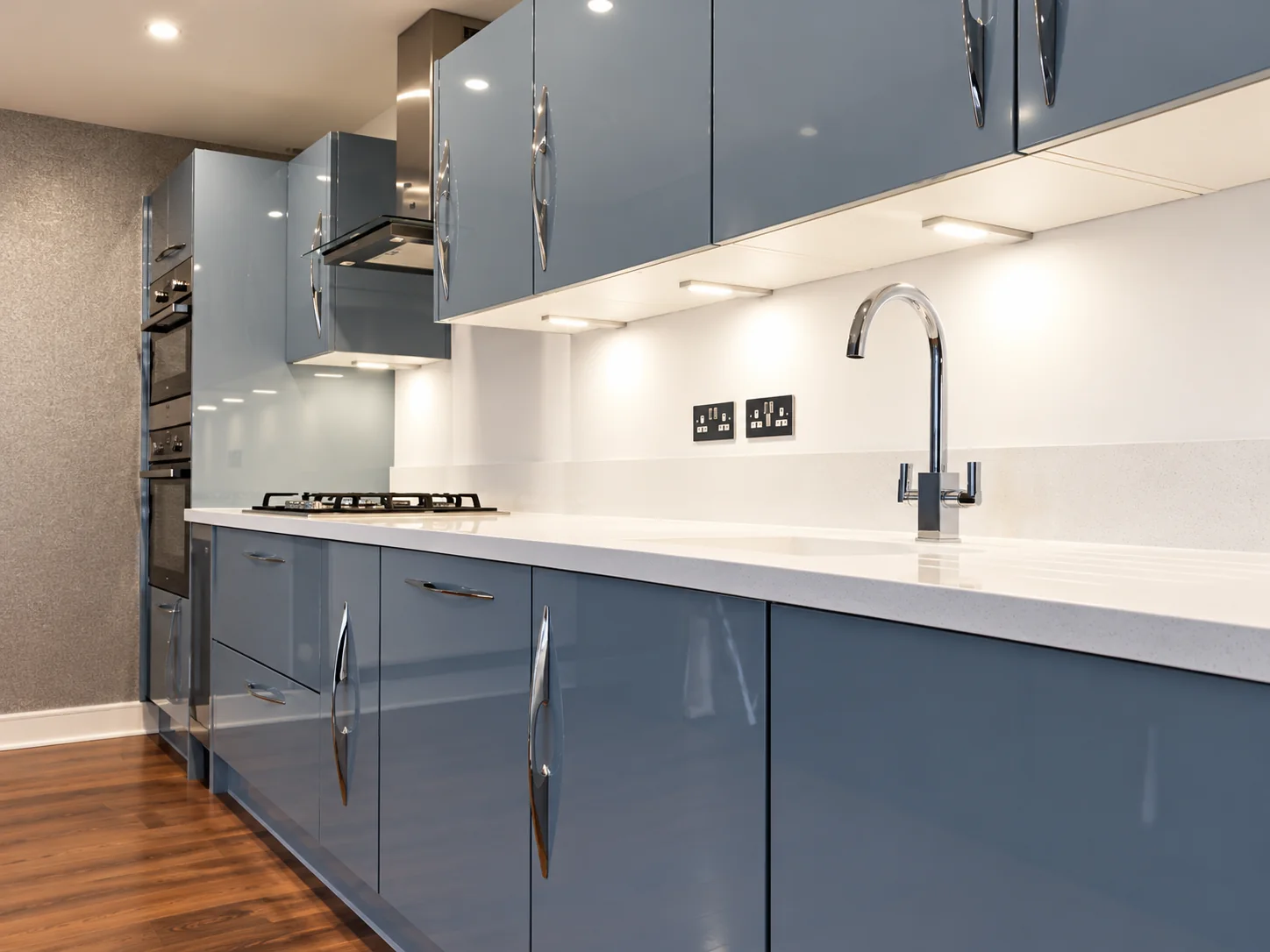 Blue handleless kitchen with white worktops installed by SM Installations