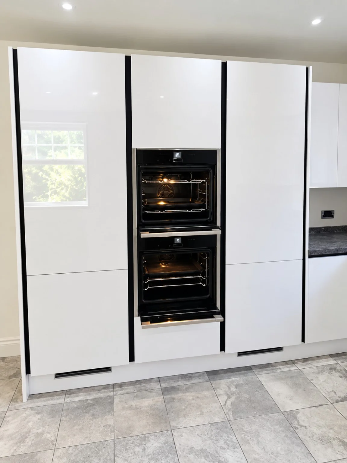 Tall white kitchen units with integrated ovens fitted by SM Installations